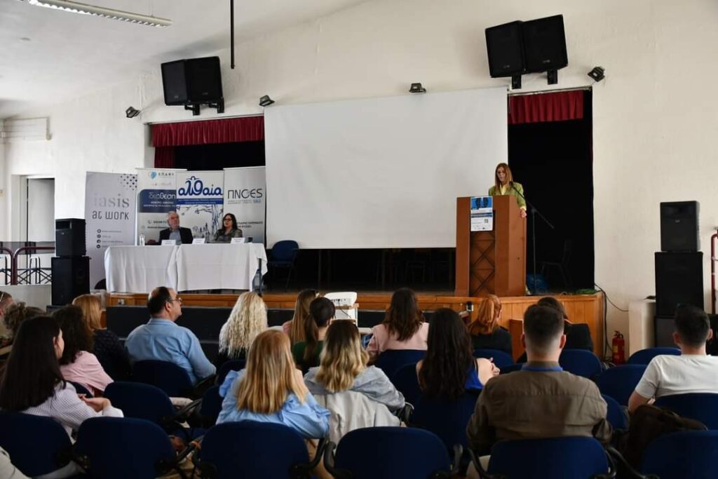 Ομιλήτρια στο βήμα και ακροατήριο στην αίθουσα της ημερίδας.
